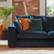 plush velvet sofa with orange and green scatter cushions