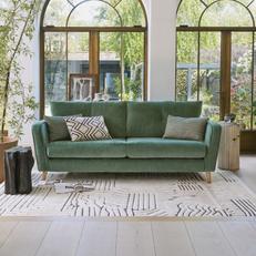 french connection carlisle sofa in sage green next to a large window
