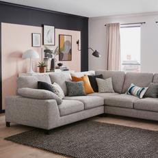 dfs euphoria corner sofa with black metal legs and various coloured scatter cushions