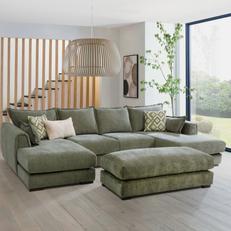 Sage green u shaped sofa with matching rectangle footstool next to a large window