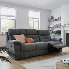 dark grey recliner sofa in a bright living with with pink scatter cushions and a white fluffy rug