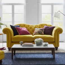 yellow chesterfield sofa with colourful patterned scatters