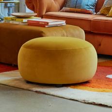 round yellow footstool on a colourful rug