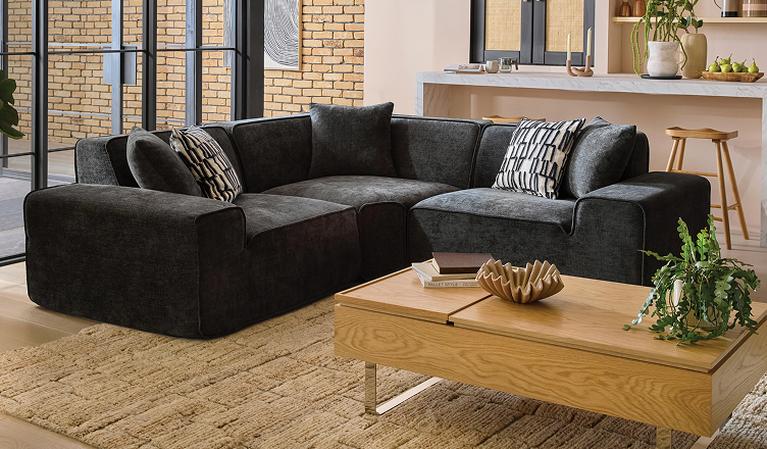OnCloud9 Flux Express Corner Sofa with monochrome scatter cushions next to an oak coffee table