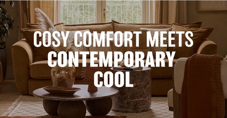 brown sofa in a dark neutral room next to dark wood and a plant