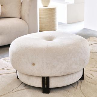 Cream round swivel footstool with dark wood feet on a white fluffy rug