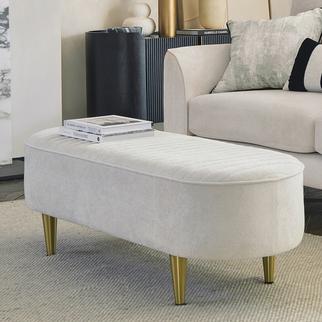 Cream bench footstool with gold metal legs and a magazine sat upon it