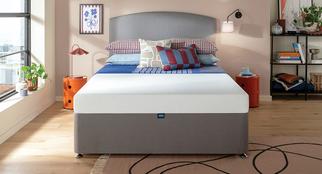 Silentnight Memory Foam mattress on a grey divan bed with bue and red bedding