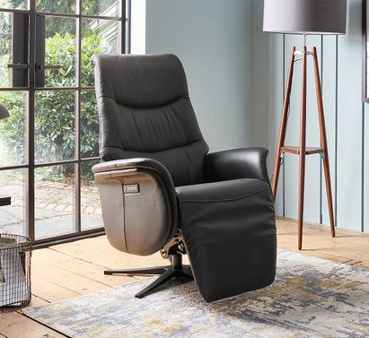 Black leather recliner chair with walnut frame in a bright living space with sage green walls