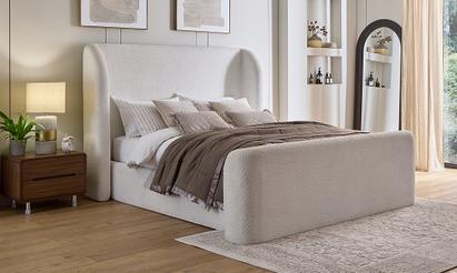 Boucle divan bed with neutral bedding and walnut bedside tables