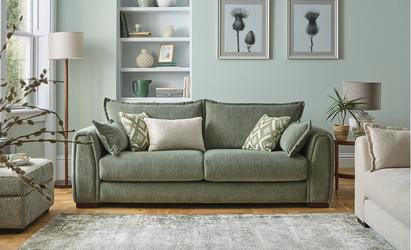 Room set of a neutral and sage green room with large window and two green sofas