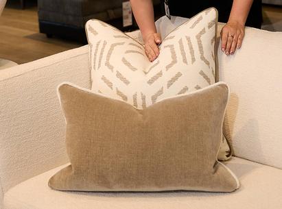 Close up of a women smoothing a brown and brown patterned scatter cushions