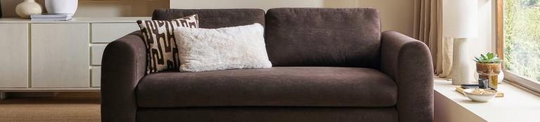 brown fabric sofa with white and monochrome scatter cushion