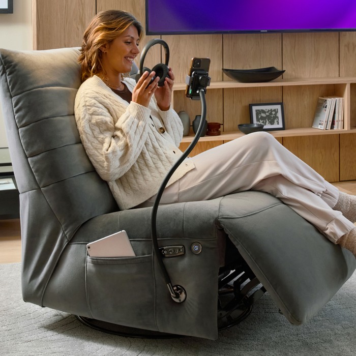 women sitting on a recliner chair putting headphones on