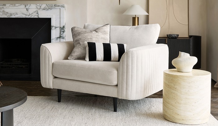 Amanda Holden Luvvie sofa in white boucle with monochrome scatters, white rug and a black coffee table