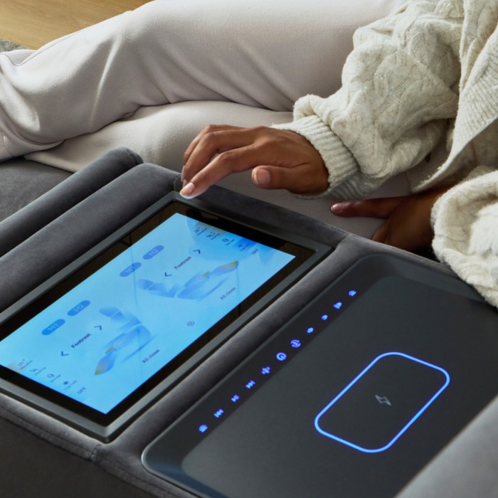 close up of someone navigating a touch screen next to a wireless charging