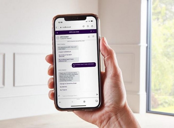 Close up of someones hand and phone on live chat talking to sales team