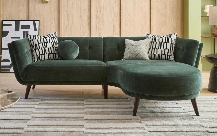 Dark Green chaise sofa with dark wood feet with monochrome patterned scatter