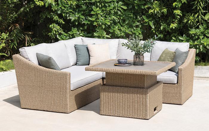 Beige rattan corner garden sofa with rising dining table with green and cream scatter cushions