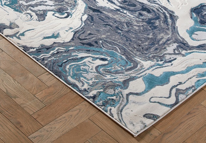 close up of a blue and white patterned rug on a wooden floor