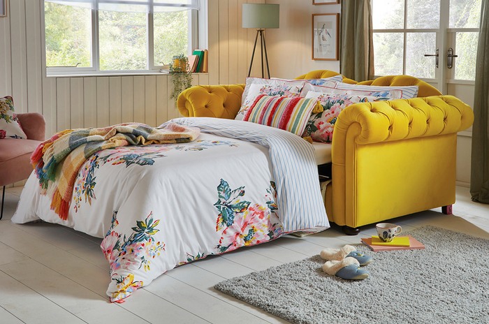 Joules Windsor chesterfield sofa bed in yellow with floral bedding and cusions