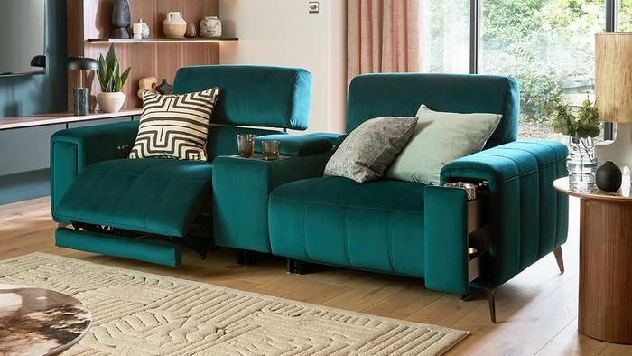 Velvet green recliner sofa with monochrome and patterned scatter cushions with a fluffy monochrome rug