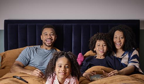 Family watching a film together in a Cinesound bed
