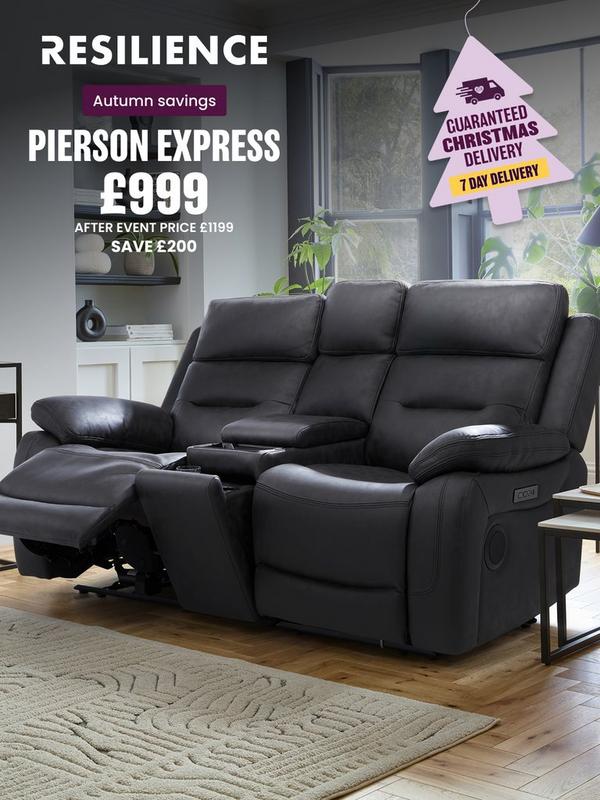 Black leather look recliner sofa with plants on surrounding tables