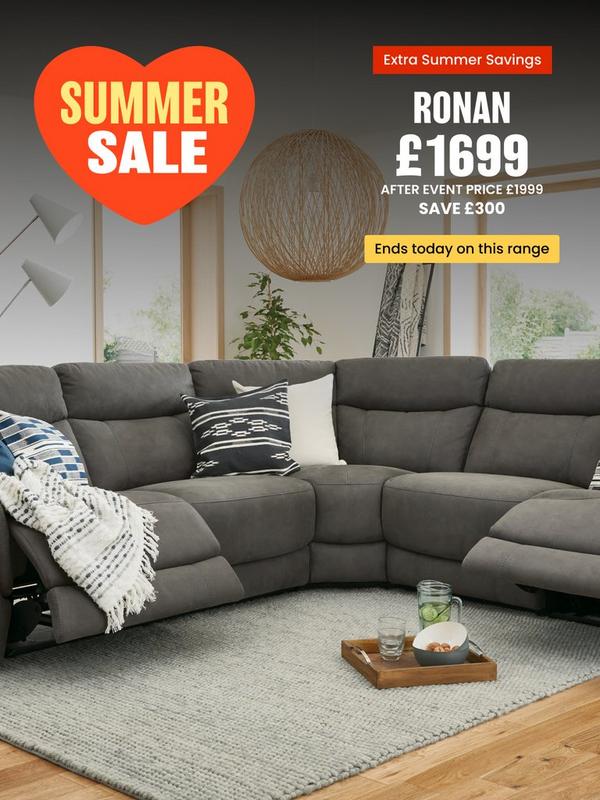 Grey reclining sofa with scatter cushions and a throw