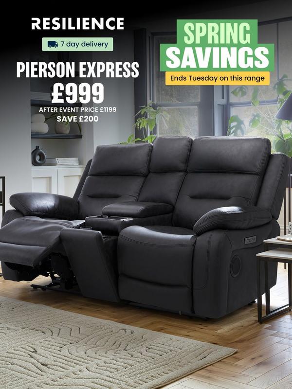 Black leather look recliner sofa with plants on surrounding tables