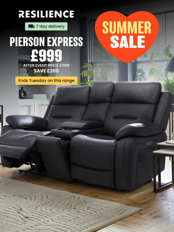 Black leather look recliner sofa with plants on surrounding tables