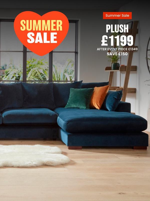 dark blue velvet corner sofa with orange and green scatter cushions