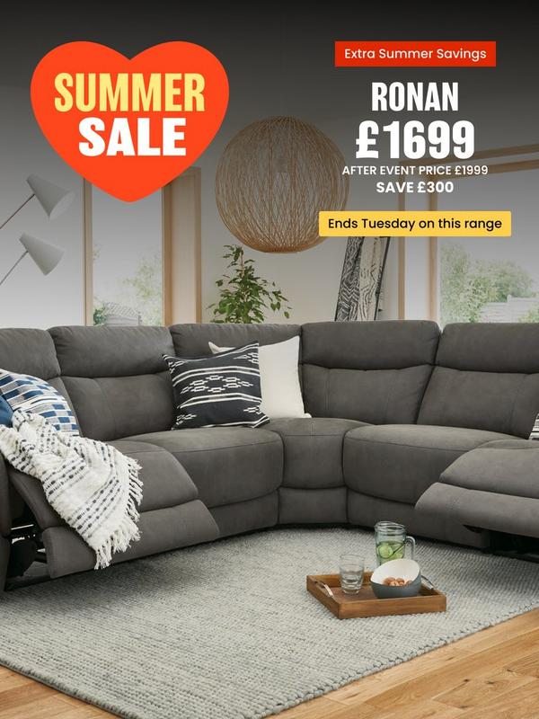 Grey reclining sofa with scatter cushions and a throw