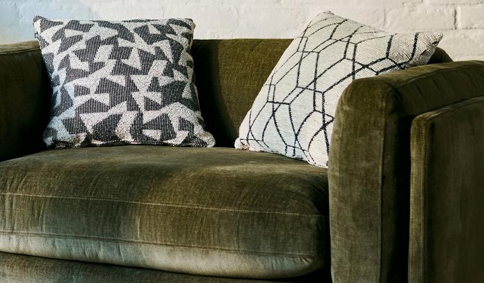 A close up image of a green velvet sofa