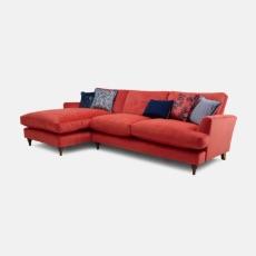 Coral velvet corner sofa with navy patterned scatter cushions