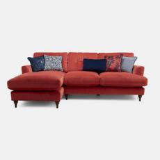 Coral velvet corner sofa with navy patterned scatter cushions