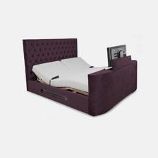 Purple bed with tv coming up at the base of the bed