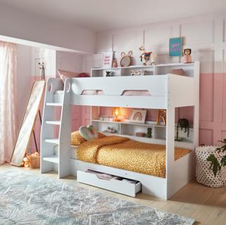 White bunk bed with yellow duvet and drawer and shelving. Pink panelled walls.