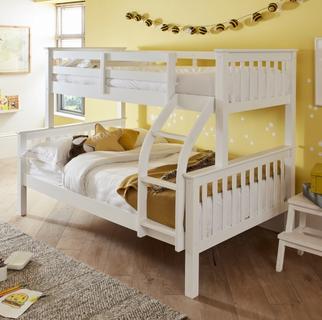 White bunk bed with a double bed on the bottom in yellow bedroom with laminate flooring