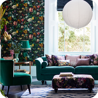 Teal sofa and matching accent chair with floral cushions and footstool