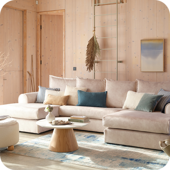 Cream double end chaise sofa with teal scatter cushions finished with a round coffee table 