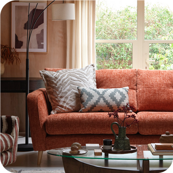 Orange fabric sofa with patterened scatter cushions