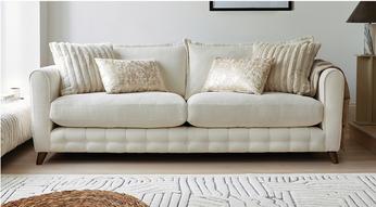 white fabric sofa with quilting and luxury scatter cushions