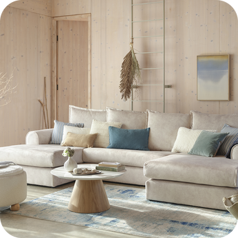 Teal sofa and matching accent chair with floral cushions and footstool