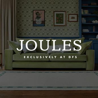 green sofa with white piping around the edge and the joules logo sat on top
