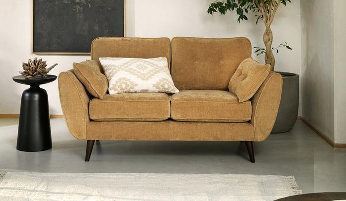 Small brown mid century chenille sofa with a black side table and white fluffy rug