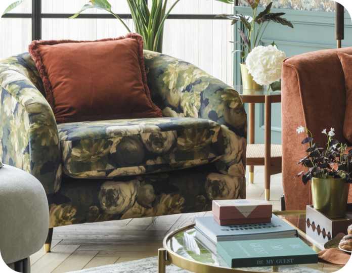 Green floral accent chair with a orange scatter cushion