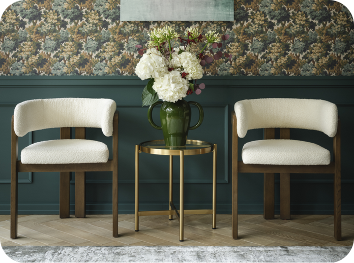 Dark wood dining chairs with boucle seat padding against a floral and teal wall