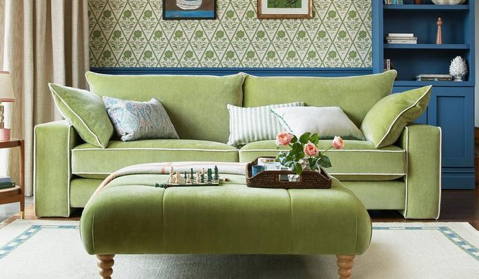 apple green chenille sofa with white piping with matching footstool on a white rug with blue border