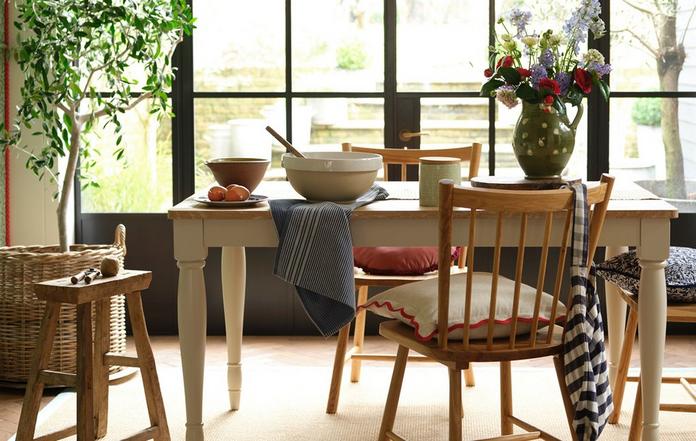 wooden dining set with two chairs next to a large window 